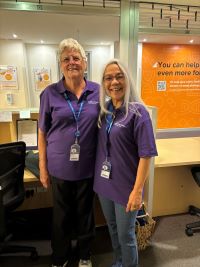 two friendly looking people wearing purple shirts